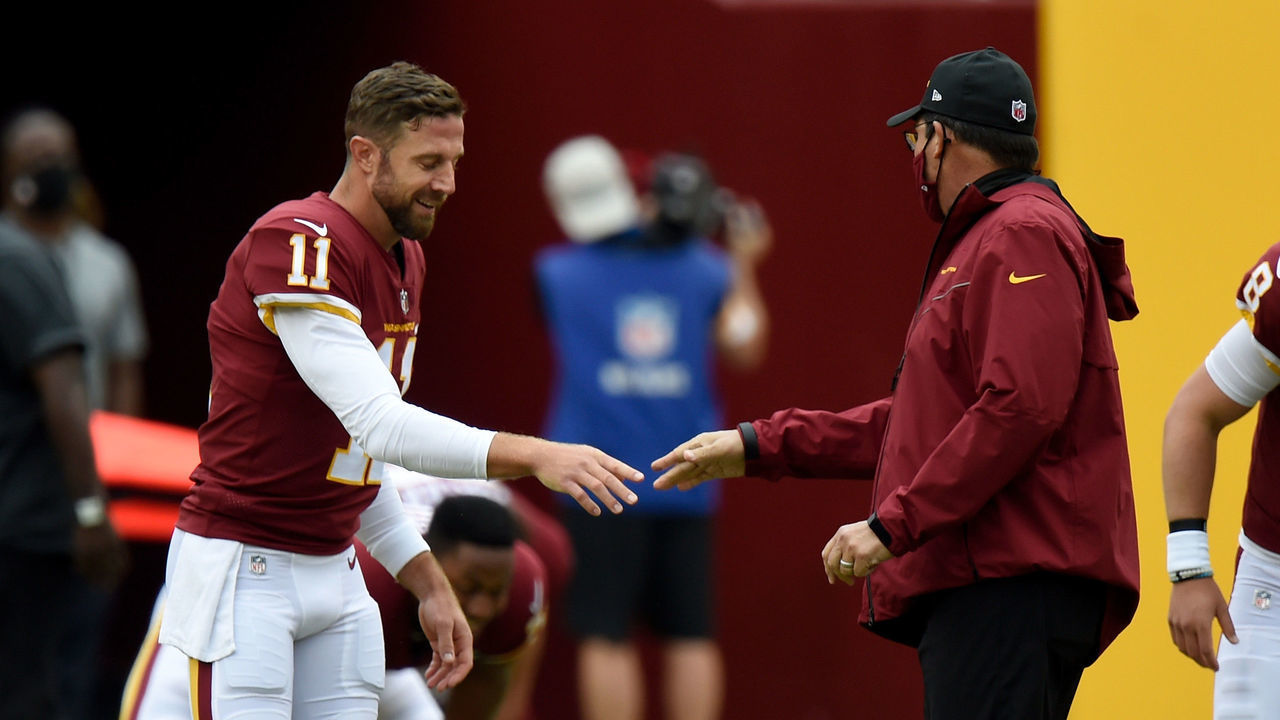 LANDOVER, MD - OCTOBER 11: Alex Smith #11 of the Washington Football Team talks with head coach Ron Rivera before the game against the Los Angeles Rams at FedExField on October 11, 2020 in Landover, Maryland.