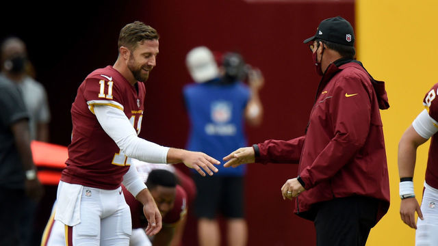 LANDOVER, MD - OCTOBER 11: Alex Smith #11 of the Washington Football Team talks with head coach Ron Rivera before the game against the Los Angeles Rams at FedExField on October 11, 2020 in Landover, Maryland.