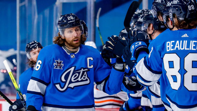 WINNIPEG, MB - JANUARY 24: Blake Wheeler #26 of the Winnipeg Jets celebrates his third period goal against the Edmonton Oilers with teammates at the bench at the Bell MTS Place on January 24, 2021 in Winnipeg, Manitoba, Canada.