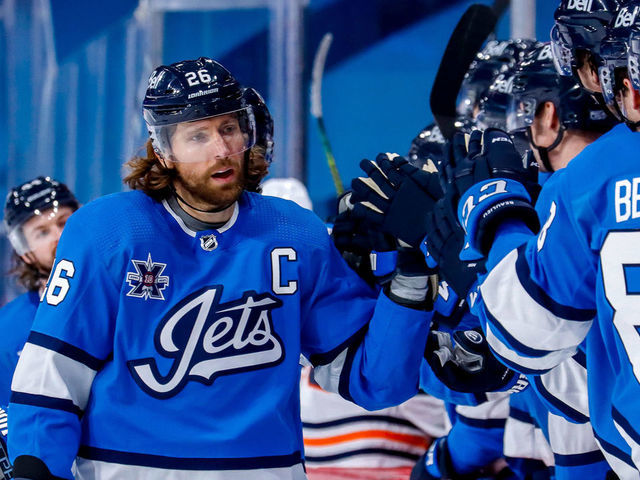 WINNIPEG, MB - JANUARY 24: Blake Wheeler #26 of the Winnipeg Jets celebrates his third period goal against the Edmonton Oilers with teammates at the bench at the Bell MTS Place on January 24, 2021 in Winnipeg, Manitoba, Canada.