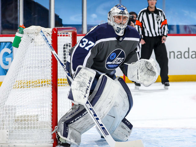 WINNIPEG, MB - FEBRUARY 4: Goaltender Connor Hellebuyck #37 of the Winnipeg Jets guards the net during first period action against the Calgary Flames at the Bell MTS Place on February 4, 2021 in Winnipeg, Manitoba, Canada.