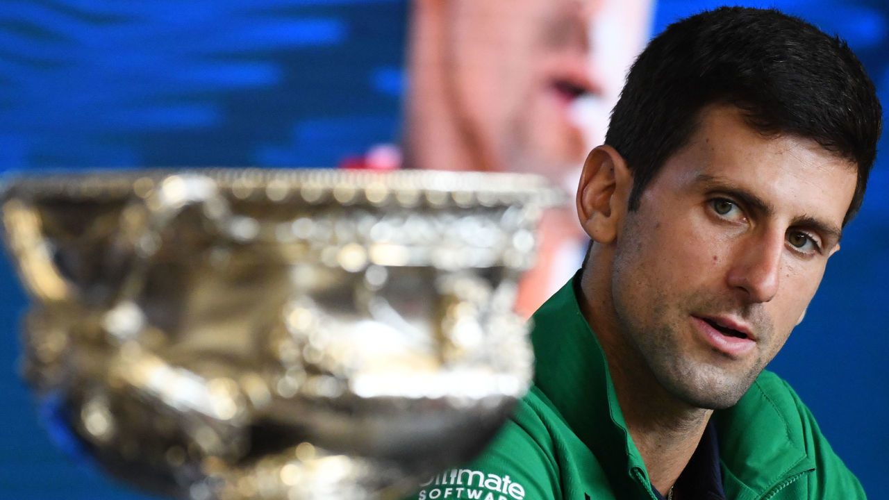 Serbia's Novak Djokovic looks at the Norman Brookes Challenge Cup trophy during a press conference after beating Austria's Dominic Thiem in their men's singles final match on day fourteen of the Australian Open tennis tournament in Melbourne on February 3, 2020.