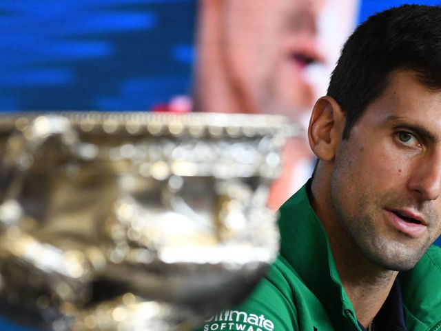 Serbia's Novak Djokovic looks at the Norman Brookes Challenge Cup trophy during a press conference after beating Austria's Dominic Thiem in their men's singles final match on day fourteen of the Australian Open tennis tournament in Melbourne on February 3, 2020.