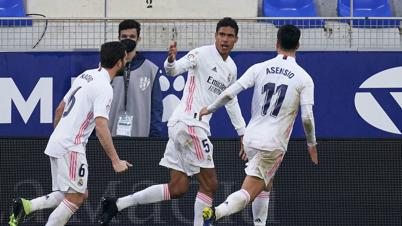 HUESCA, SPAIN - FEBRUARY 06: Raphael Varane of Real Madrid celebrates after scoring his team's second goal during the La Liga Santander match between SD Huesca and Real Madrid at Estadio El Alcoraz on February 06, 2021 in Huesca, Spain. Sporting stadiums around Spain remain under strict restrictions due to the Coronavirus Pandemic as Government social distancing laws prohibit fans inside venues resulting in games being played behind closed doors.