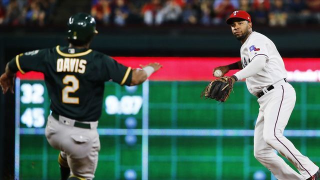 ARLINGTON, TX - SEPTEMBER 29: Elvis Andrus #1 of the Texas Rangers throws to first base on a double play as Khris Davis #2 of the Oakland Athletics slides to second base during the second inning at Globe Life Park in Arlington on September 29, 2017 in Arlington, Texas.