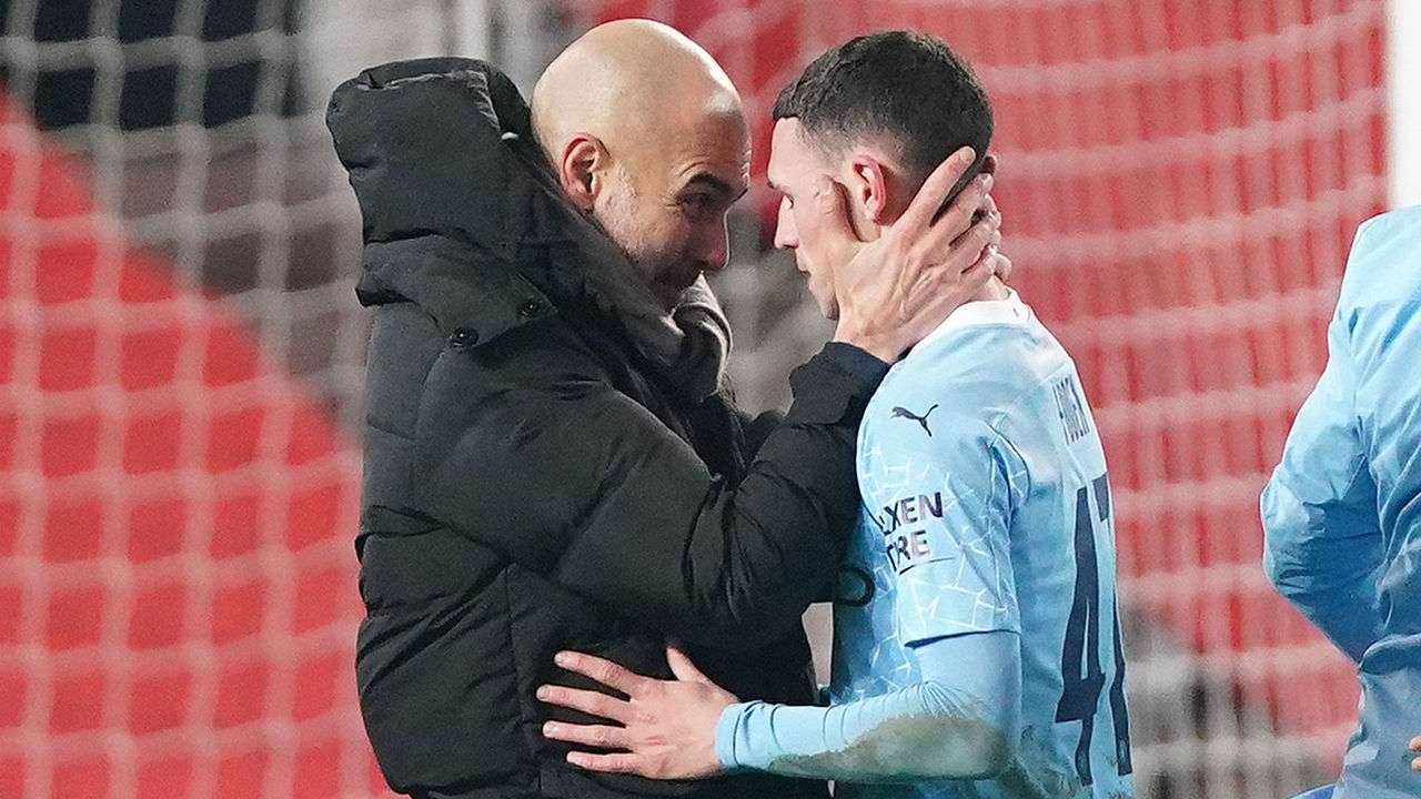 MANCHESTER, ENGLAND - JANUARY 06: Pep Guardiola, Manager of Manchester City celebrates with Phil Foden of Manchester City after the final whistle during the Carabao Cup Semi Final match between Manchester United and Manchester City at Old Trafford on January 06, 2021 in Manchester, England. The match will be played without fans, behind closed doors as a Covid-19 precaution.