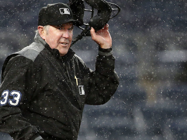 NEW YORK, NY - MAY 5: Umpire Mike Winters #33 takes off his mask as he gets set to signal that he is stopping the game in the heavy rain after a wild pitch during the 8th inning in an MLB baseball game on May 5, 2019 at Yankee Stadium in the Bronx borough of New York City. Yankees won 4-1.