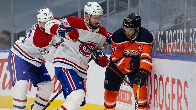 EDMONTON, AB - JANUARY 18: Connor McDavid #97 of the Edmonton Oilers battles against Joel Edmundson #44 of the Montreal Canadiens at Rogers Place on January 18, 2021 in Edmonton, Canada.
