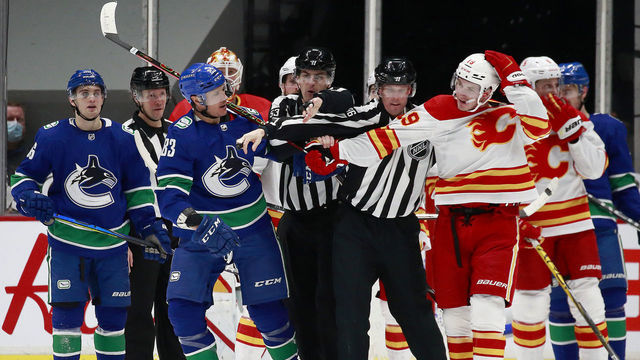 VANCOUVER, BC - FEBRUARY 11: Linesman separate Jay Beagle #83 of the Vancouver Canucks and Matthew Tkachuk #19 of the Calgary Flames during their NHL game at Rogers Arena on February 11, 2021 in Vancouver, British Columbia, Canada.