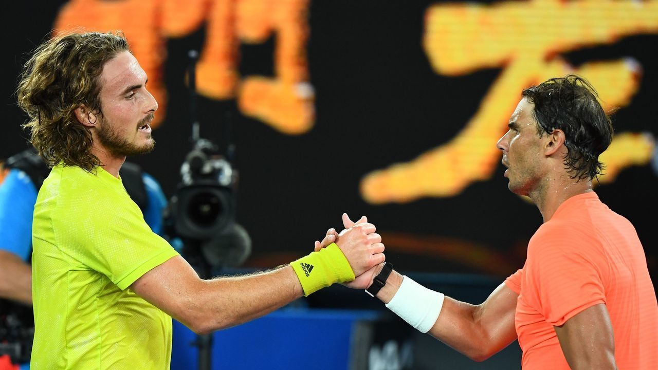 Greece's Stefanos Tsitsipas (L) and Spain's Rafael Nadal greet each other after their men's singles quarter-final match on day ten of the Australian Open tennis tournament in Melbourne on February 17, 2021.