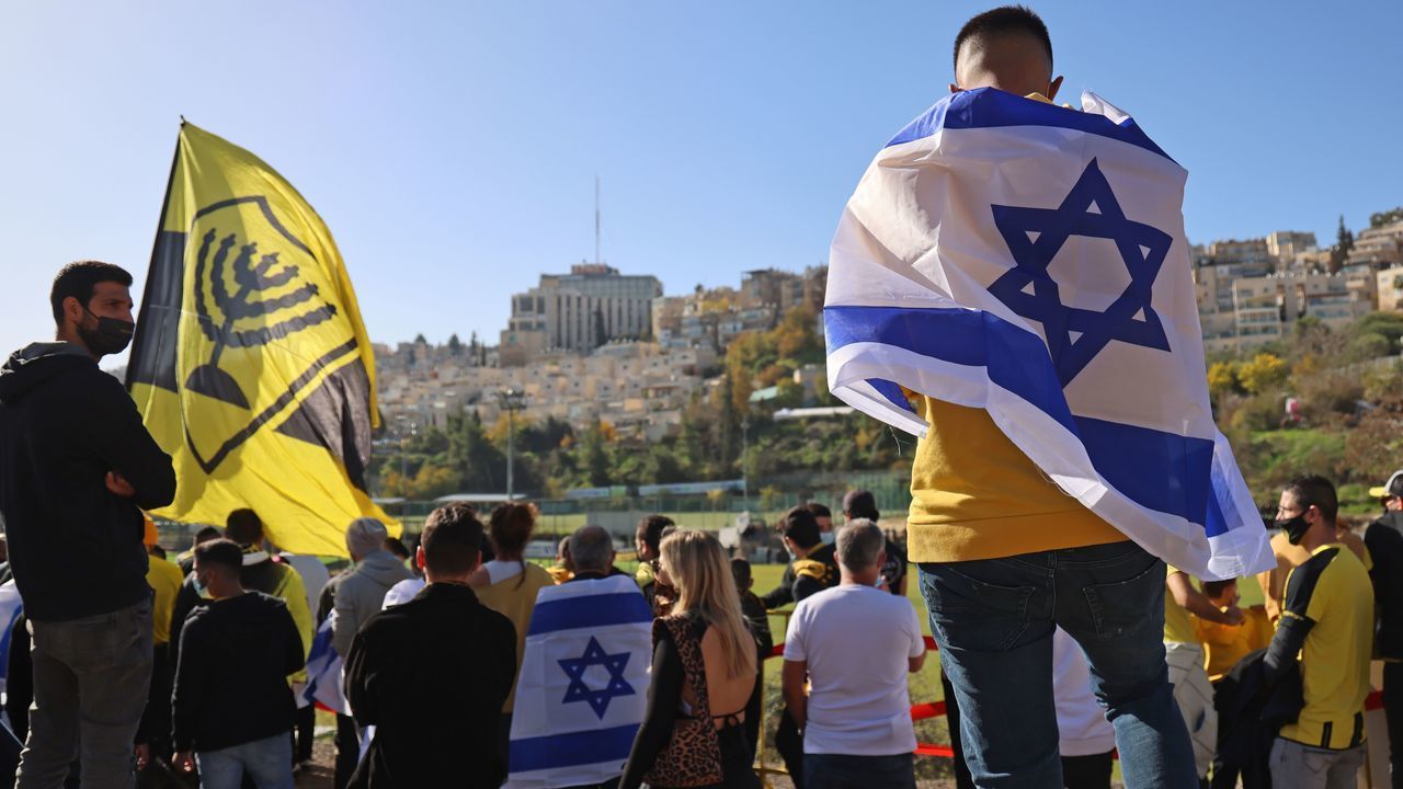 Fans of Israeli Beitar Jerusalem football club show their support during the team's training in Jerusalem on December 11, 2020, after a member of Abu Dhabi's royal family bought half of Beitar. - The agreement comes after Israel established ties with UAE and Bahrain, only the third and fourth only Arab nations to normalise relations with the Jewish state after Egypt and Jordan. Beitar Jerusalem's fans have historically been considered anti-Muslim and anti-Arab, with their far-right "La Familia" fan group known for its chants against the Prophet Mohammed. The first division club is the only Israeli side never to have fielded an Arab player.