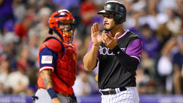 DENVER, CO - AUGUST 25: Nolan Arenado #28 of the Colorado Rockies claps in front of Yadier Molina #4 of the St. Louis Cardinals after scoring an eighth inning run at Coors Field on August 25, 2018 in Denver, Colorado. Players are wearing special jerseys with their nicknames on them during Players' Weekend.