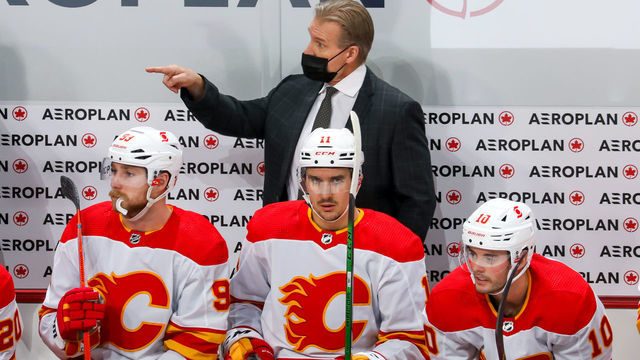 WINNIPEG, MANITOBA - JANUARY 14: Head Coach Geoff Ward of the Calgary Flames gives instructions behind players Sam Bennett #93, Mikael Backlund #11, and Derek Ryan #10 during second period action against the Winnipeg Jets at Bell MTS Place on January 14, 2021 in Winnipeg, Manitoba.