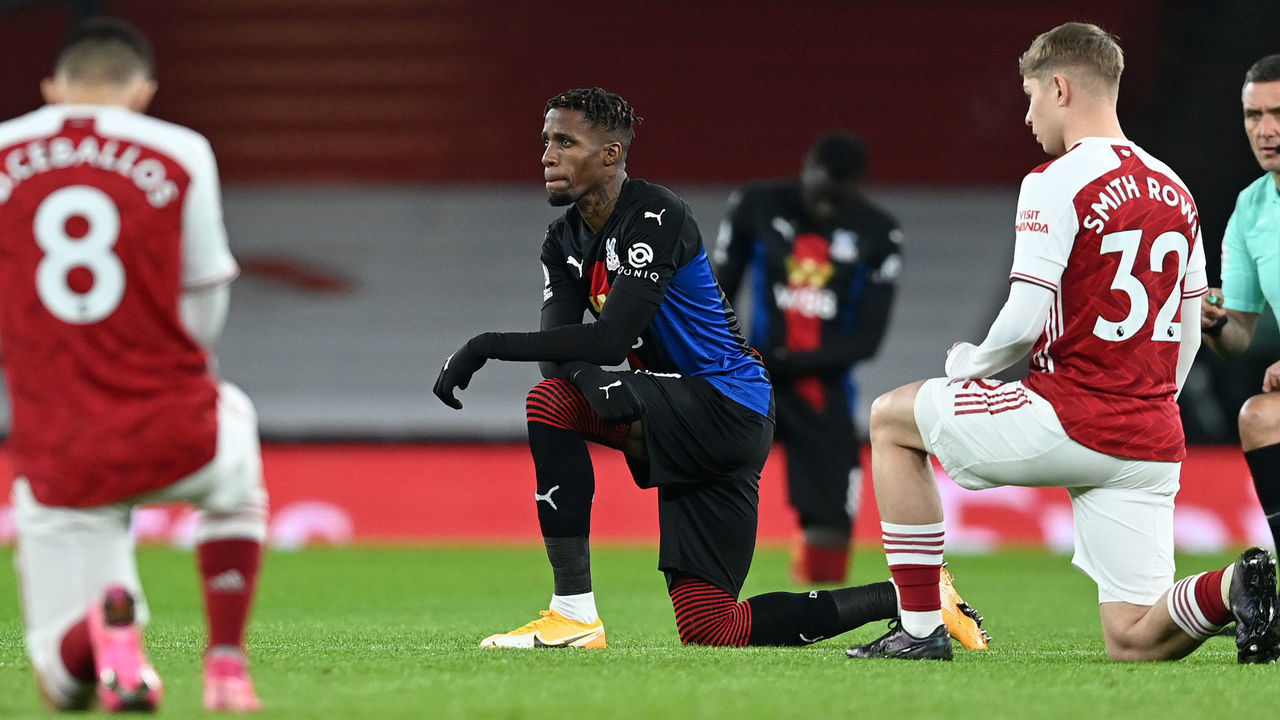 LONDON, ENGLAND - JANUARY 14: Wilfried Zaha of Crystal Palace and Emile Smith Rowe of Arsenal take a knee for the Black Lives Matter Movement prior to the Premier League match between Arsenal and Crystal Palace at Emirates Stadium on January 14, 2021 in London, England. Sporting stadiums around England remain under strict restrictions due to the Coronavirus Pandemic as Government social distancing laws prohibit fans inside venues resulting in games being played behind closed doors.