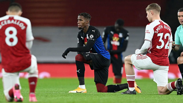 LONDON, ENGLAND - JANUARY 14: Wilfried Zaha of Crystal Palace and Emile Smith Rowe of Arsenal take a knee for the Black Lives Matter Movement prior to the Premier League match between Arsenal and Crystal Palace at Emirates Stadium on January 14, 2021 in London, England. Sporting stadiums around England remain under strict restrictions due to the Coronavirus Pandemic as Government social distancing laws prohibit fans inside venues resulting in games being played behind closed doors.