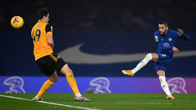 LONDON, ENGLAND - JANUARY 27: Hakim Ziyech of Chelsea shoots under pressure from Maximilin Kilman of Wolverhampton Wanderers during the Premier League match between Chelsea and Wolverhampton Wanderers at Stamford Bridge on January 27, 2021 in London, England. Sporting stadiums around the UK remain under strict restrictions due to the Coronavirus Pandemic as Government social distancing laws prohibit fans inside venues resulting in games being played behind closed doors.