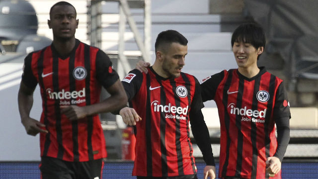 Frankfurt's Japanese midfielder Daichi Kamada (R) celebrates with Frankfurt's French defender Evan N'Dicka (L) and Frankfurt's Serbian midfielder Filip Kostic (C) after scoring the 1-0 during the German first division Bundesliga football match Eintracht Frankfurt vs FC Bayern Munich in Frankfurt am Main, western Germany, on February 20, 2021.