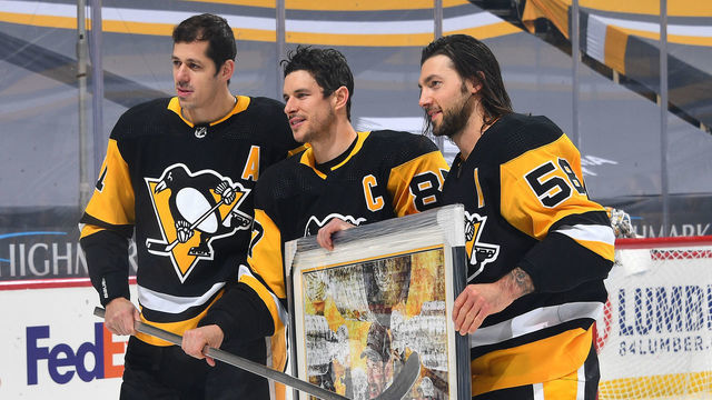 PITTSBURGH, PA - FEBRUARY 20: Sidney Crosby #87 of the Pittsburgh Penguins poses for photos with Evgeni Malkin #71 and Kris Letang #58 during pregame ceremonies honoring Crosby's 1000th game at PPG PAINTS Arena on February 20, 2021 in Pittsburgh, Pennsylvania.
