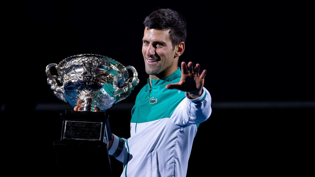 MELBOURNE, AUSTRALIA - FEBRUARY 21: Novak Djokovic of Serbia holds the Norman Brookes Challenge Cup as he celebrates victory in his Men’s Singles Final match against Daniil Medvedev of Russia during day 14 of the 2021 Australian Open at Melbourne Park on February 21, 2021 in Melbourne, Australia.