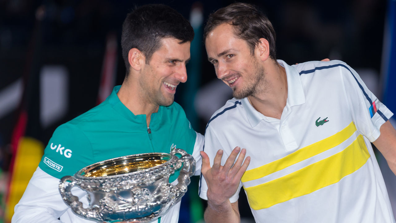 MELBOURNE, AUSTRALIA - FEBRUARY 21: Novak Djokovic of Serbia holds the Norman Brookes Challenge Cup as he shares a joke with opponent Daniil Medvedev of Russia following their Men’s Singles Final match during day 14 of the 2021 Australian Open at Melbourne Park on February 21, 2021 in Melbourne, Australia.