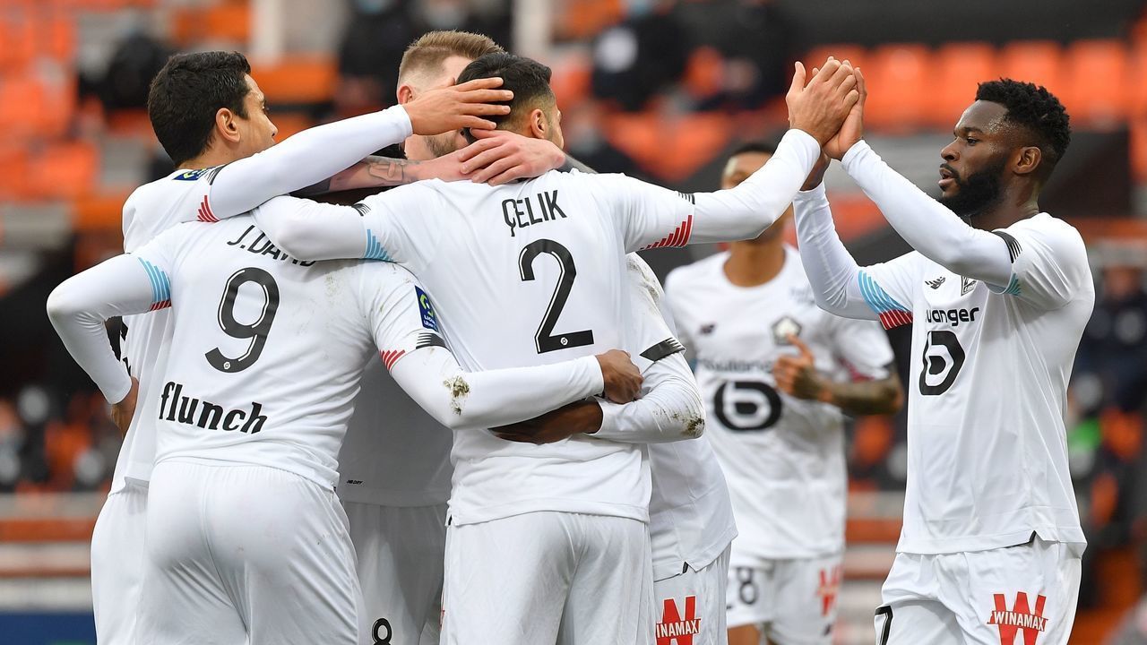 Lille's Canadian forward Jonathan David (L) celebrates with teammates after scoring a goal during the French L1 football match between FC Lorient and Lille at the Moustoir Stadium in Lorient, western France, on February 21, 2021.