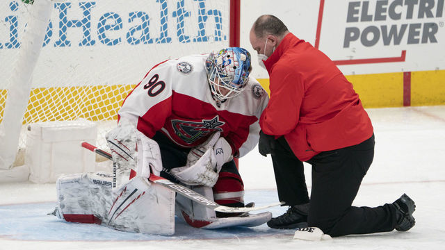 COLUMBUS, OH - FEBRUARY 20: Columbus Blue Jackets goaltender Elvis Merzlikins #90 being looked at by team physician after being injured during the game between the Columbus Blue Jackets and the Nashville Predators at Nationwide Arena in Columbus, Ohio on February 20, 2021.