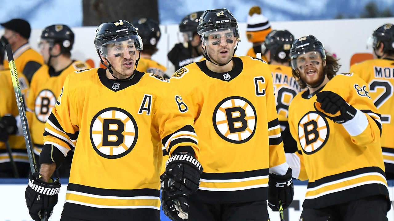 STATELINE, NEVADA - FEBRUARY 21: (L-R) Brad Marchand #63, Patrice Bergeron #37 and David Pastrnak #88 of the Boston Bruins celebrate after teammate Charlie McAvoy #73 (not pictured) scored against the Philadelphia Flyers during the first period of the 2021 NHL Outdoors Sunday presented by Honda on the 18th fairway of the Edgewood Tahoe Resort, at the south shore of Lake Tahoe on February 21, 2021 in Stateline, Nevada.