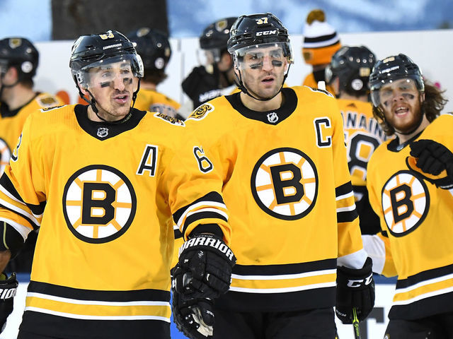 STATELINE, NEVADA - FEBRUARY 21: (L-R) Brad Marchand #63, Patrice Bergeron #37 and David Pastrnak #88 of the Boston Bruins celebrate after teammate Charlie McAvoy #73 (not pictured) scored against the Philadelphia Flyers during the first period of the 2021 NHL Outdoors Sunday presented by Honda on the 18th fairway of the Edgewood Tahoe Resort, at the south shore of Lake Tahoe on February 21, 2021 in Stateline, Nevada.