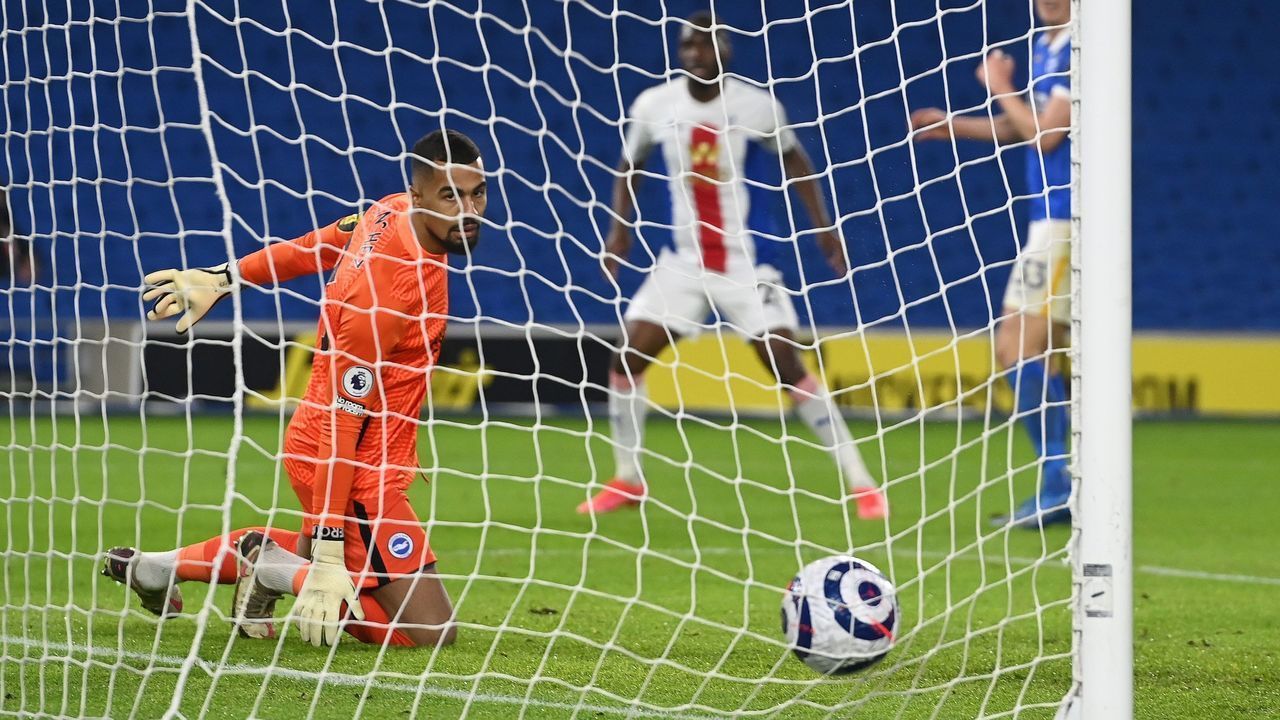 Brighton's Spanish goalkeeper Robert Sanchez (L) watches the ball into the net as he concedes a goal from Crystal Palace's Zaire-born Belgian striker Christian Benteke during the English Premier League football match between Brighton and Hove Albion and Crystal Palace at the American Express Community Stadium in Brighton, southern England on February 22, 2021. - Crystal Palace won the match 2-0.