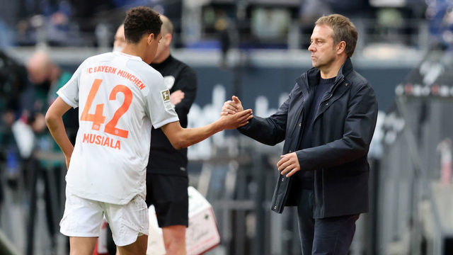 FRANKFURT AM MAIN, GERMANY - FEBRUARY 20: Coach Hansi Hans Flick of Bayern Muenchen and Jamal Musiala of Bayern Muenchen during the Bundesliga match between Eintracht Frankfurt and FC Bayern Muenchen at Deutsche Bank Park on February 20, 2021 in Frankfurt am Main, Germany. Sporting stadiums around Germany remain under strict restrictions due to the Coronavirus Pandemic as Government social distancing laws prohibit fans inside venues resulting in games being played behind closed doors.