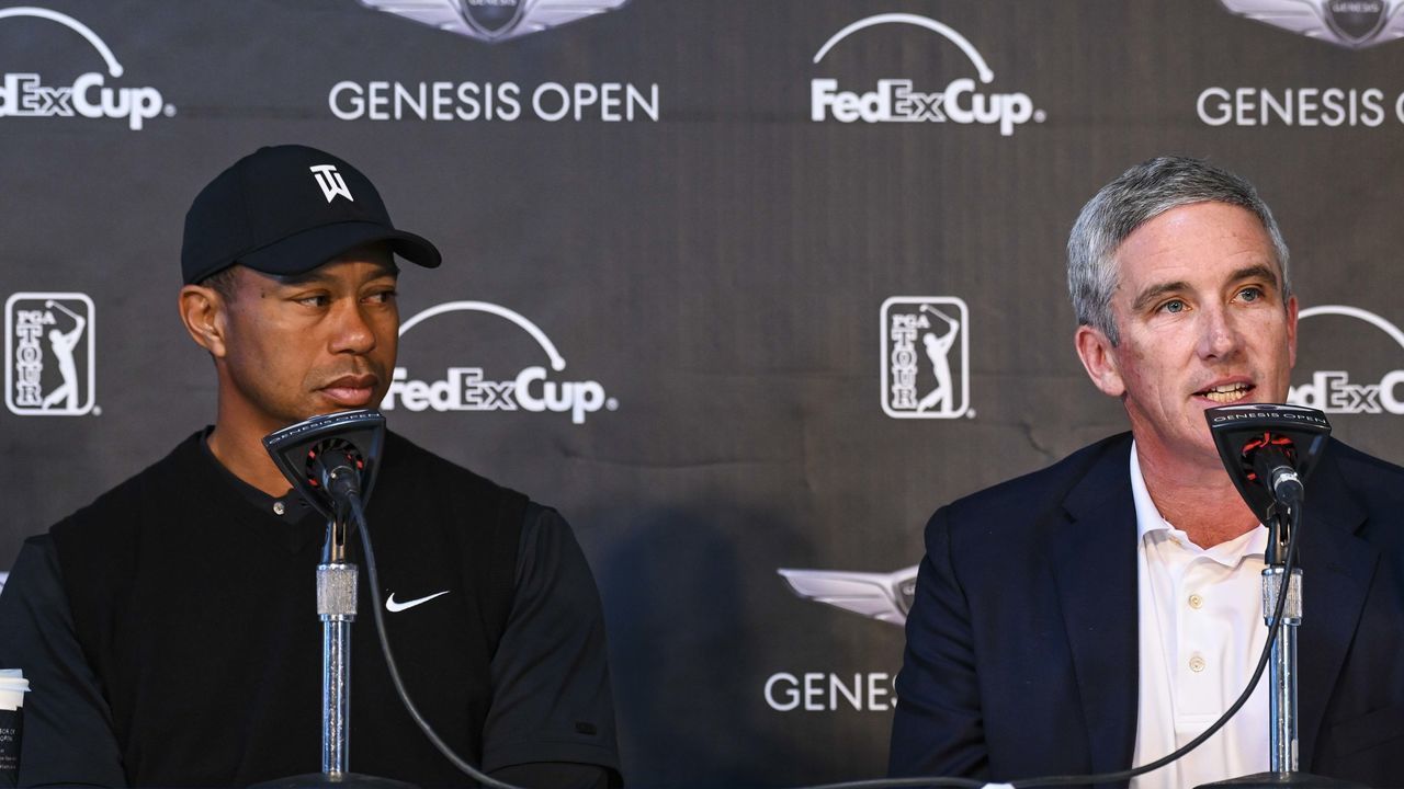 PACIFIC PALISADES, CA - FEBRUARY 13: Tiger Woods listens to PGA TOUR Commissioner Jay Monahan speak about a tournament elevation and sponsorship announcement following his pro-am practice round at the Genesis Open at Riviera Country Club on February 13, 2019 in Pacific Palisades, California.