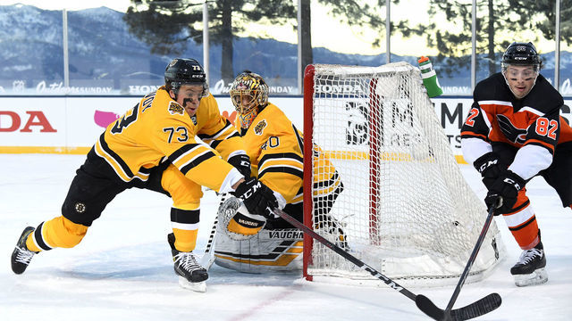 STATELINE, NEVADA - FEBRUARY 21: Charlie McAvoy #73 of the Boston Bruins reaches for the puck against Connor Bunnaman #82 of the Philadelphia Flyers during the first period of the 2021 NHL Outdoors Sunday presented by Honda on the 18th fairway of the Edgewood Tahoe Resort, at the south shore of Lake Tahoe on February 21, 2021 in Stateline, Nevada.