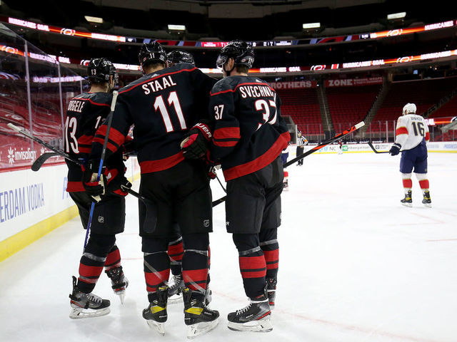 RALEIGH, NC - FEBRUARY 17: Jordan Staal #11 of the Carolina Hurricanes scores a goal and celebrates with teammates Andrei Svechnikov #37 and Warren Foegele #13 during an NHL game against the Florida Panthers on February 17, 2021 at PNC Arena in Raleigh, North Carolina.