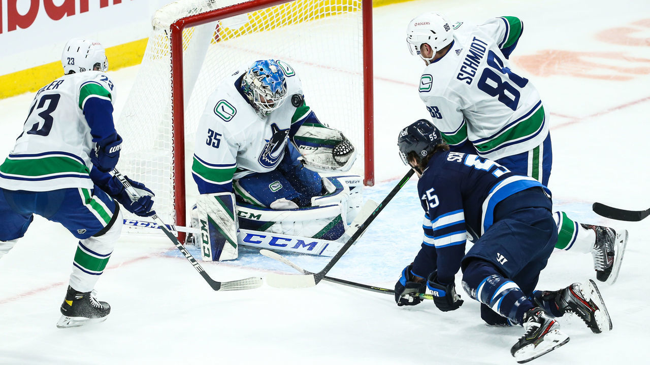WINNIPEG, MB March 01: Vancouver Canucks goalie Thatcher Demko (35) makes a save on a shot by Winnipeg Jets forward Mark Scheifele (55) during the regular season game between the Winnipeg Jets and the Vancouver Canucks on March 01, 2021 at the Bell MTS Place in Winnipeg MB.