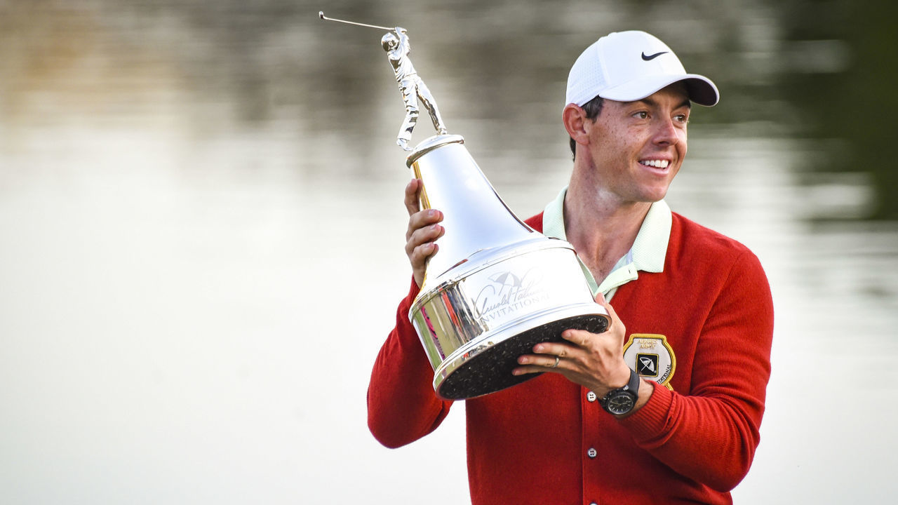 ORLANDO, FL - MARCH 18: Rory McIlroy of Northern Ireland smiles and holds the tournament trophy while wearing a replica Arnold Palmer red cardigan following his three stroke victory on the 18th hole green in the final round of the Arnold Palmer Invitational presented by MasterCard at Bay Hill Club and Lodge on March 18, 2018 in Orlando, Florida.