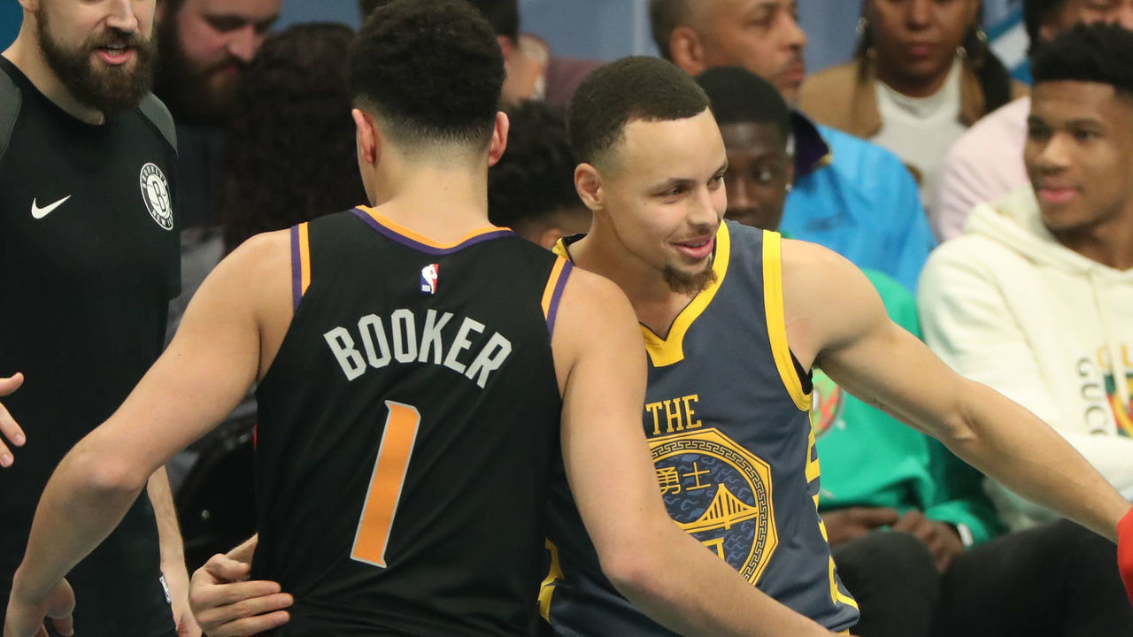 CHARLOTTE, NC - FEBRUARY 16: Devin Booker #1 of the Pheonix Suns hugs Stephen Curry #30 of the Golden State Warriors during the 2019 Mtn Dew 3-Point Contest as part of State Farm All-Star Saturday Night on February 16, 2019 at the Spectrum Center in Charlotte, North Carolina. NOTE TO USER: User expressly acknowledges and agrees that, by downloading and/or using this photograph, user is consenting to the terms and conditions of the Getty Images License Agreement. Mandatory Copyright Notice: Copyright 2019 NBAE