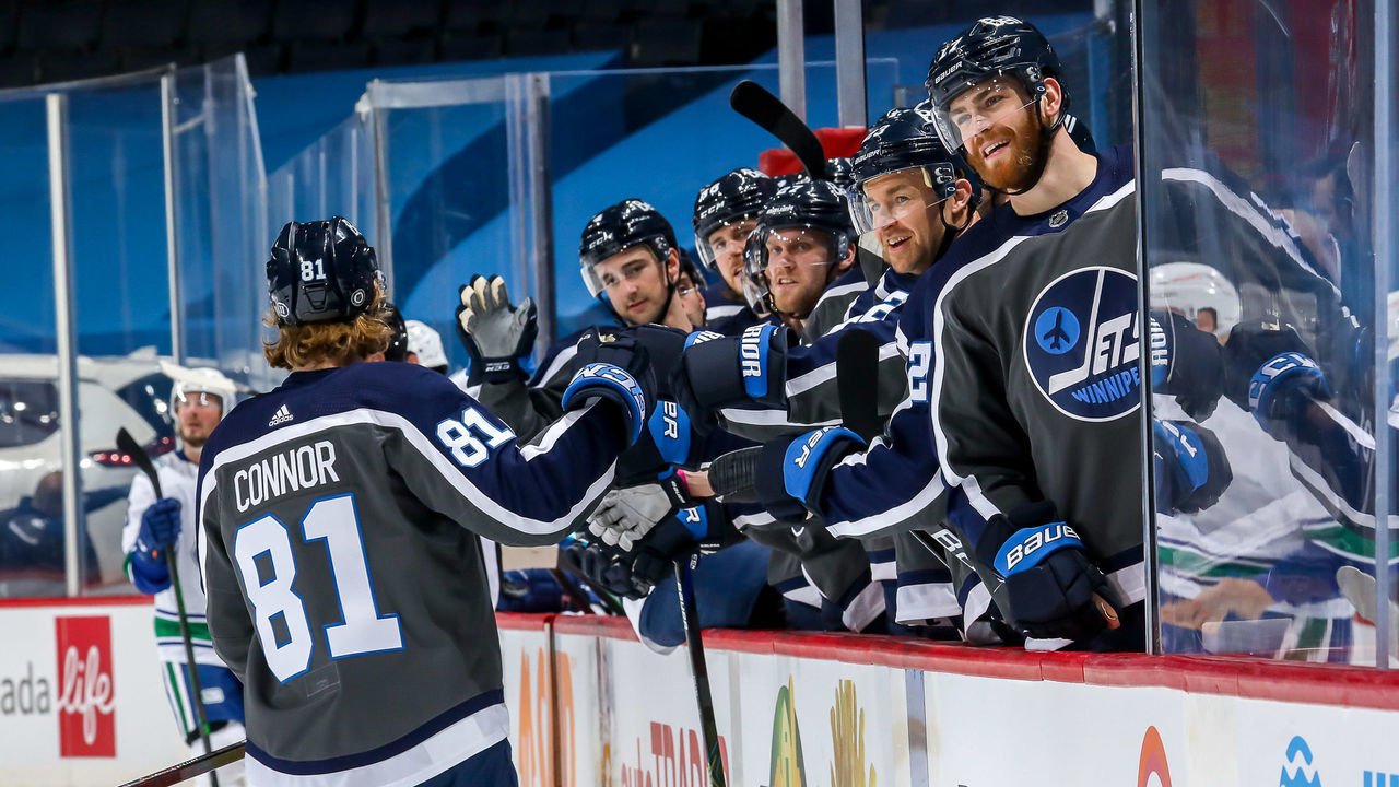 WINNIPEG, MB - MARCH 2: Kyle Connor #81 of the Winnipeg Jets celebrates his second period goal against the Vancouver Canucks with teammates at the bench at the Bell MTS Place on March 2, 2021 in Winnipeg, Manitoba, Canada.