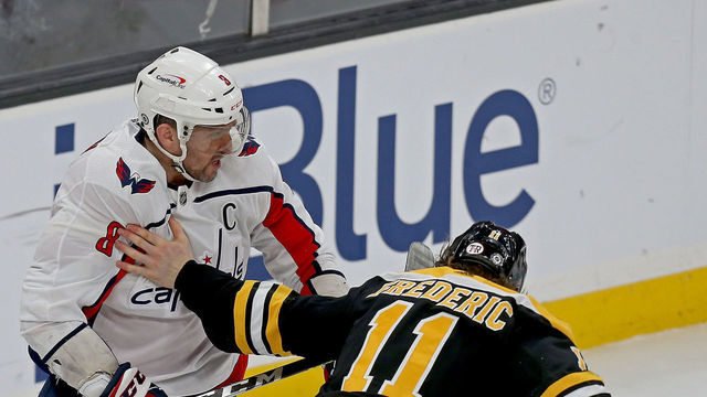 Boston, MA. - March 3: Trent Frederic #11 of the Boston Bruins takes his gloves off to try to fight with Alex Ovechkin #8 of the Washington Capitals during the third period of the NHL game at the TD garden on March 3, 2021 in Boston, Massachusetts. (Staff Photo By Matt Stone/MediaNews Group/Boston Herald)