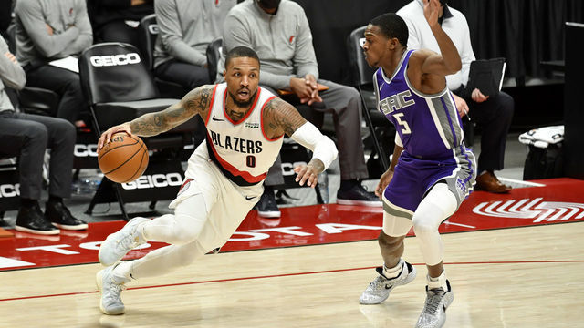 PORTLAND, OREGON - MARCH 04: Damian Lillard #0 of the Portland Trail Blazers drives to the basket against De'Aaron Fox #5 of the Sacramento Kings during the first half of an NBA game at the Moda Center on March 04, 2021 in Portland, Oregon. NOTE TO USER: User expressly acknowledges and agrees that, by downloading and or using this photograph, User is consenting to the terms and conditions of the Getty Images License Agreement.