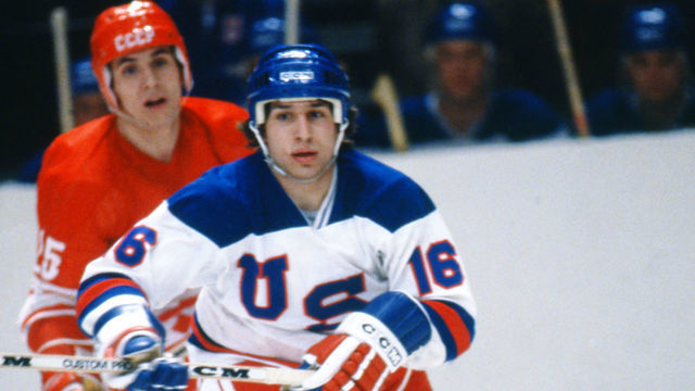 LAKE PLACID, NY - FEBRUARY 22: Vladimir Golikov #25 of the USSR battles with Mark Pavelich #16 of Team USA during the 1980 Olympic Games on February 22, 1980 at the Olympic Center in Lake Placid, New York.