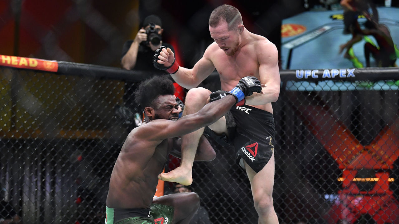 LAS VEGAS, NEVADA - MARCH 06: (R-L) Petr Yan of Russia delivers an illegal knee against Aljamain Sterling in their UFC bantamweight championship fight during the UFC 259 event at UFC APEX on March 06, 2021 in Las Vegas, Nevada.
