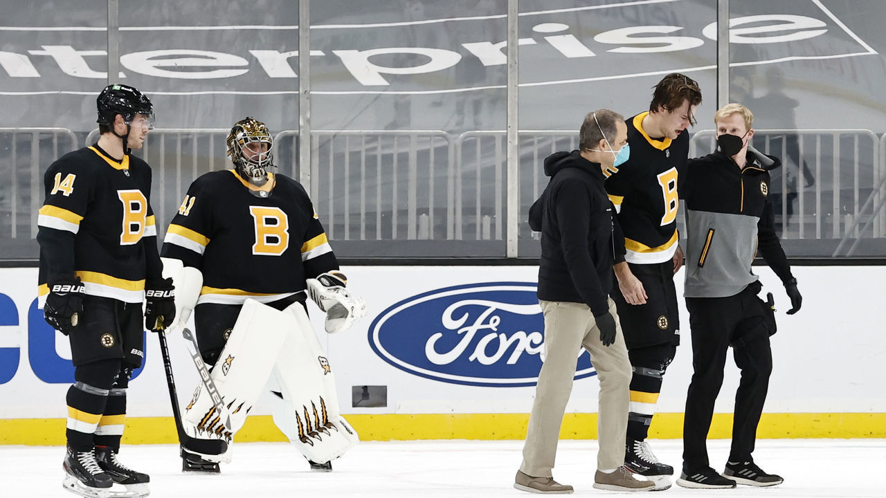 BOSTON, MA - MARCH 05: Boston Bruins right defenseman Brandon Carlo (25) is helped off the ice after being injured during a game between the Boston Bruins and the Washington Capitals on March 5, 2021, at TD Garden in Boston, Massachusetts.