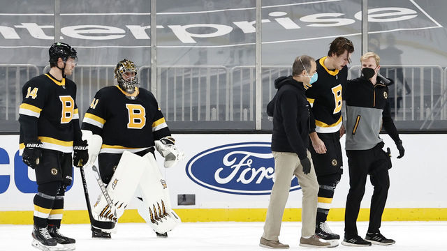 BOSTON, MA - MARCH 05: Boston Bruins right defenseman Brandon Carlo (25) is helped off the ice after being injured during a game between the Boston Bruins and the Washington Capitals on March 5, 2021, at TD Garden in Boston, Massachusetts.