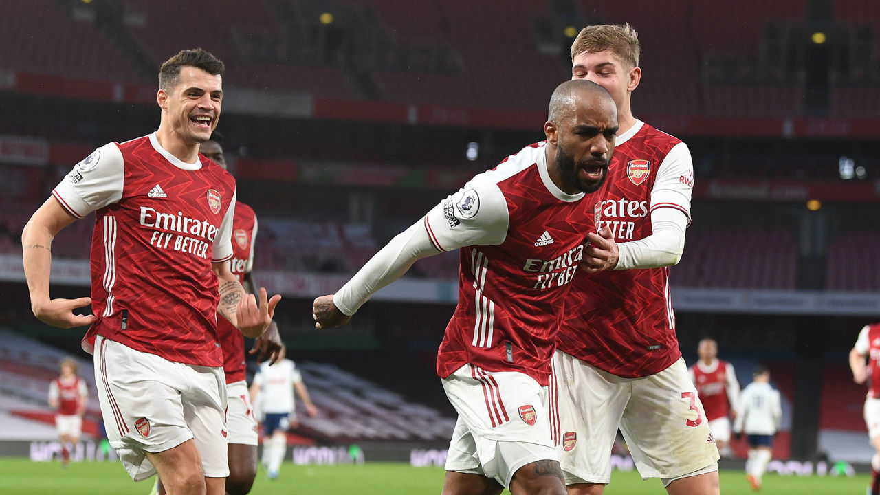LONDON, ENGLAND - MARCH 14: (2ndR) Alex Lacazette celebrates scoring the 2nd Arsenal goal with (L) Granit Xhaka and (R) Emile Smith Rowe during the Premier League match between Arsenal and Tottenham Hotspur at Emirates Stadium on March 14, 2021 in London, England. Sporting stadiums around the UK remain under strict restrictions due to the Coronavirus Pandemic as Government social distancing laws prohibit fans inside venues resulting in games being played behind closed doors.