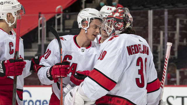 DETROIT, MI - MARCH 14: Sebastian Aho #20 of the Carolina Hurricanes congratulates teammate Alex Nedeljkovic #39 after an NHL game against the Detroit Red Wings at Little Caesars Arena on March 14, 2021 in Detroit, Michigan. Carolina defeated Detroit 2-1.