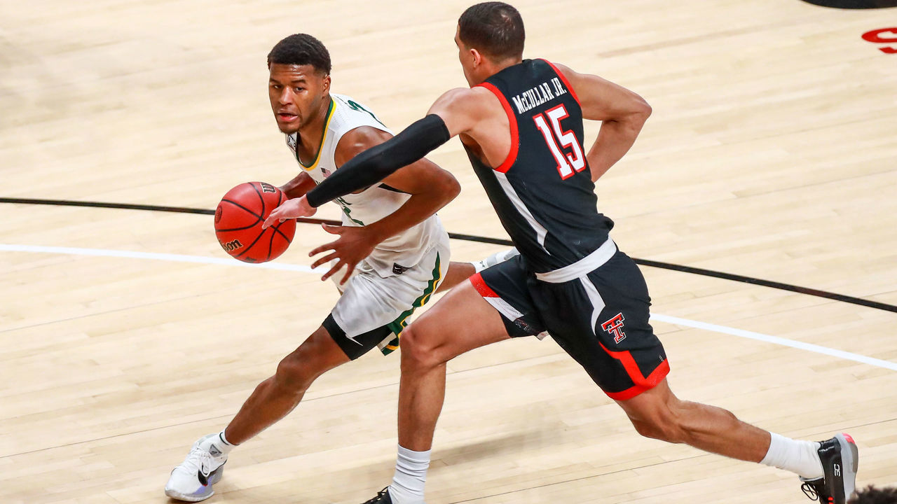 LUBBOCK, TEXAS - JANUARY 16: Guard Jared Butler #12 of the Baylor Bears handles the ball against guard Kevin McCullar #15 of the Texas Tech Red Raiders during the first half of the college basketball game at United Supermarkets Arena on January 16, 2021 in Lubbock, Texas.