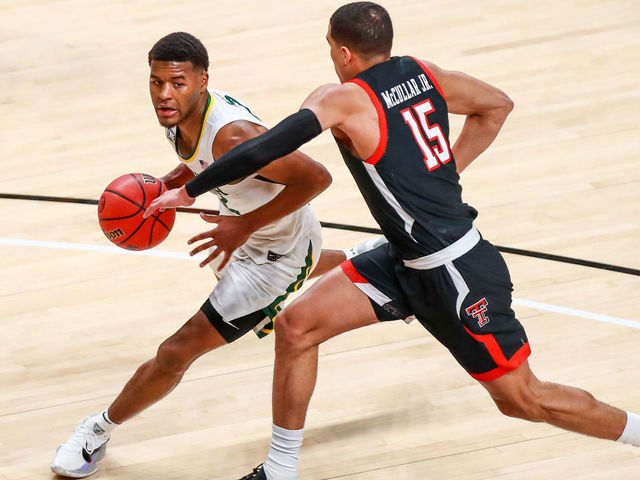 LUBBOCK, TEXAS - JANUARY 16: Guard Jared Butler #12 of the Baylor Bears handles the ball against guard Kevin McCullar #15 of the Texas Tech Red Raiders during the first half of the college basketball game at United Supermarkets Arena on January 16, 2021 in Lubbock, Texas.