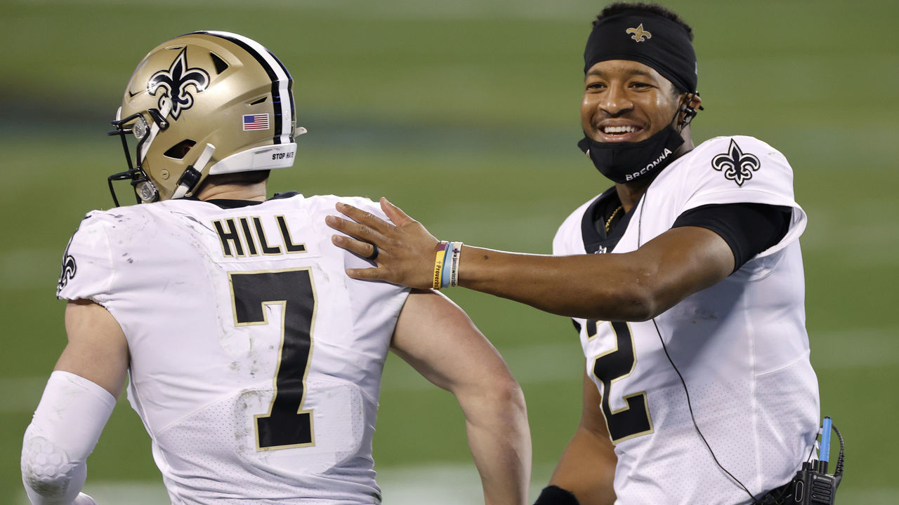 CHARLOTTE, NORTH CAROLINA - JANUARY 03: Quarterback Jameis Winston #2 of the New Orleans Saints shares a smile as he greets teammate quarterback Taysom Hill #7 during the second half of their game against the Carolina Panthers at Bank of America Stadium on January 03, 2021 in Charlotte, North Carolina.