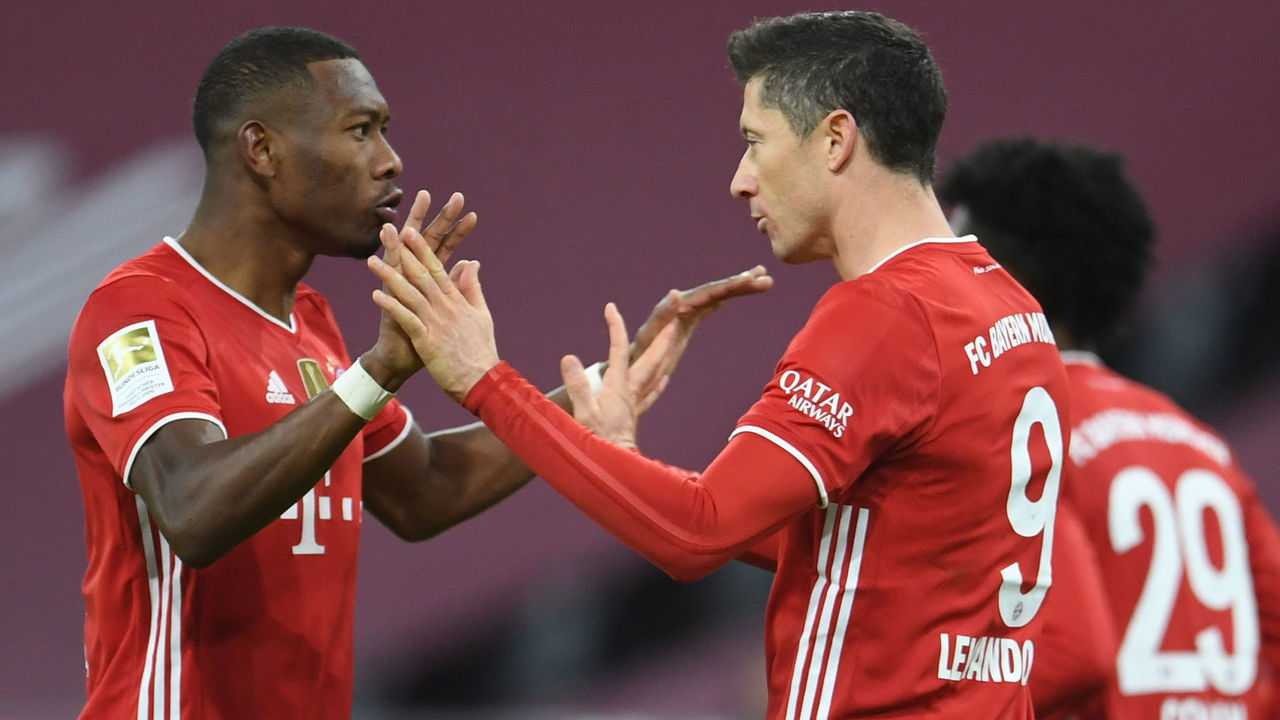 Bayern Munich's Polish forward Robert Lewandowski celebrates after scoring the equalising goal with Bayern Munich's Austrian defender David Alaba during the German first division Bundesliga football match between FC Bayern Munich and BVB Borussia Dortmund in Munich, southern Germany, on March 6, 2021.