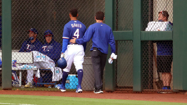 SURPRISE, ARIZONA - MARCH 23: Khris Davis #4 of the Texas Rangers exits the game with an injury after hitting in the first inning against the Los Angeles Angels during the MLB spring training game at Surprise Stadium on March 23, 2021 in Surprise, Arizona.